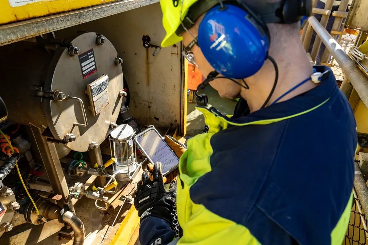 Technician pointing an explosion-proof iPhone at process equipment in a hazardous area