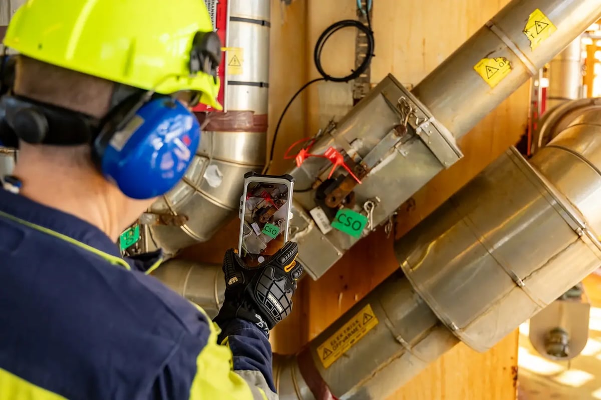 Technician photographing a tagged valve with an explosion-proof iPhone